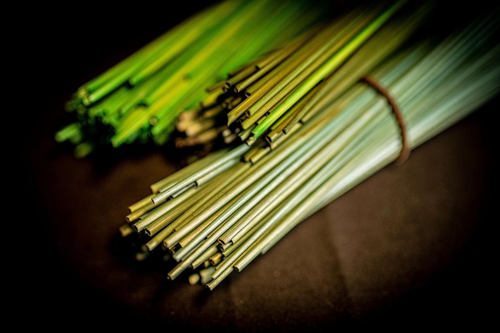 Photo de paille brut et colorées de vert avant leur préparation pour la marqueterie de paille